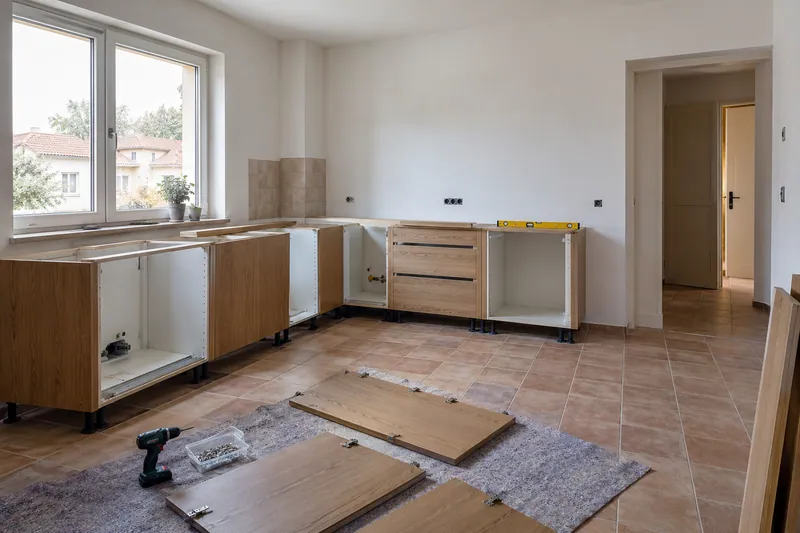 Visualización conceptual IA: Módulos de cocina en montaje con puertas pendientes de colocar.